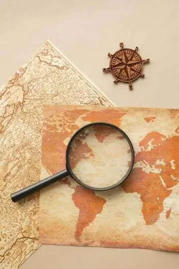 Vue en plongée d'une carte vintage avec loupe et boussole pour les thèmes d'exploration.